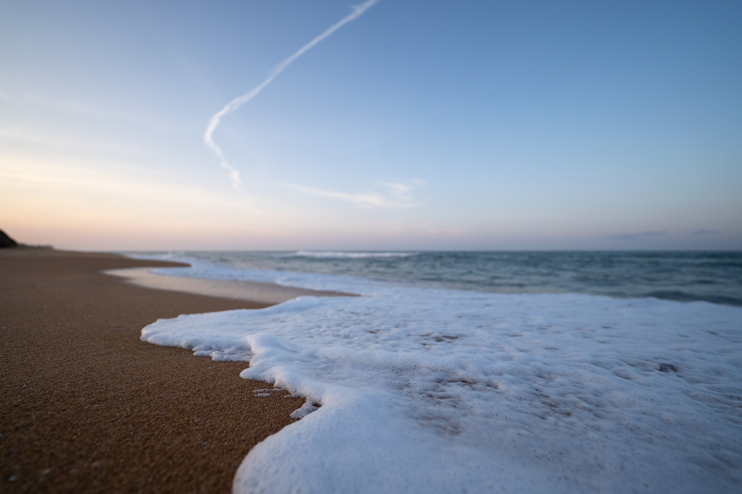 A beach scene of a tiny wave washing ashore