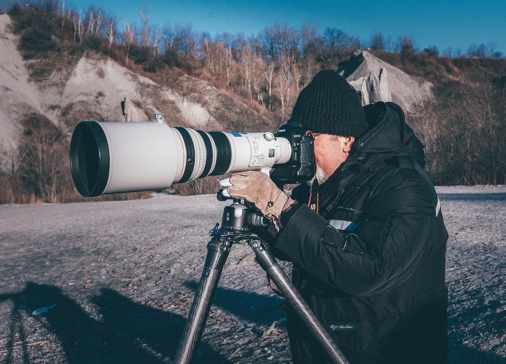 Man using a telephoto lens to take a photo.