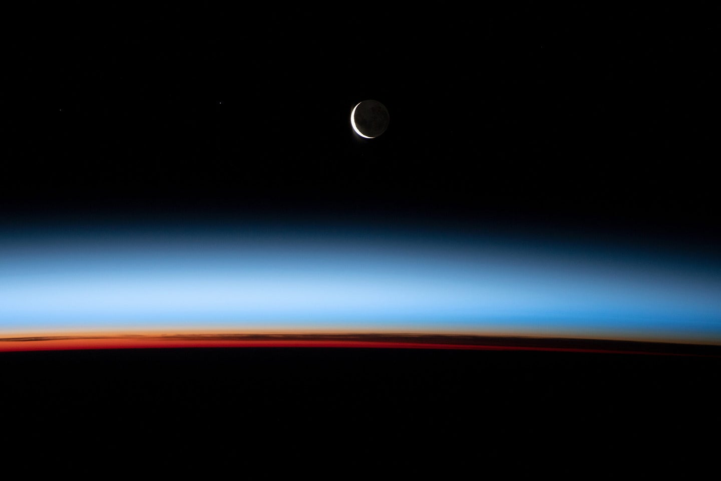 A crescent moon and sunset, captured from the ISS.